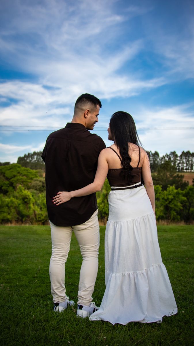 O casal abraçado, de costas, olhando o campo